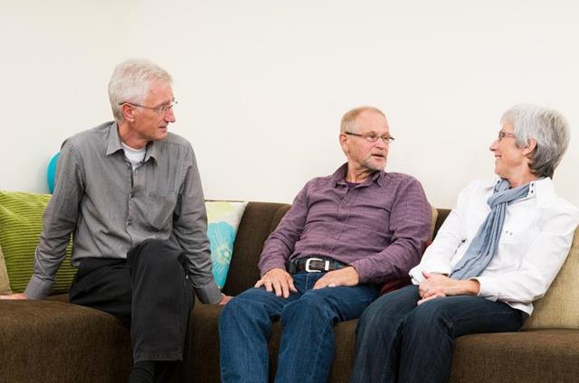 three family members talking on a couch