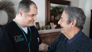 A caregiver is flipping through a book with his client